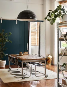 A modern, industrial-style dining room with a wooden table and metal chairs.