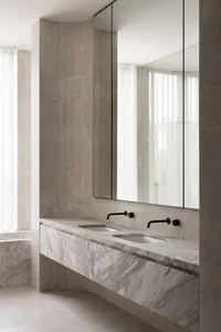 Modern minimalist bathroom with marble sink and countertop, large mirror, and white curtains.