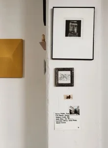 極簡室內牆面懸掛畫框，包含素描與照片畫作。