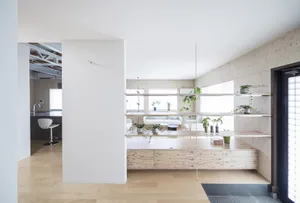A minimalist living room featuring wooden elements and plants.
