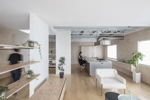 A minimalist residential kitchen with wooden surfaces and modern design elements.