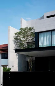 Modern residential house with concrete exterior and large windows.