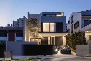 Modern residential building with concrete exterior and illuminated windows.