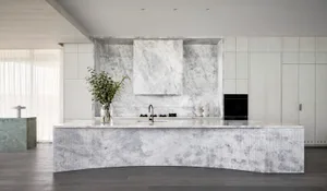 A modern kitchen featuring marble countertops and backsplash with minimalist design.