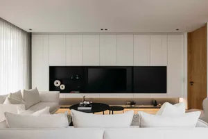 Modern living room with minimalist design and white furniture.