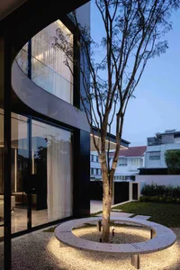 Modern minimalist patio area with terrazzo flooring and a single tree at the center.