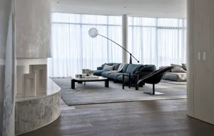 Modern minimalist living room with concrete and glass elements, featuring a contemporary sofa and armchair, wooden flooring, 