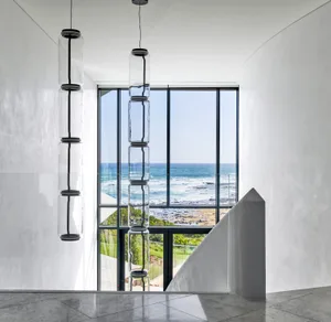 Modern residential interior with large glass window showcasing coastal view