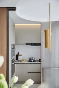A minimalist kitchen with marble countertops and cabinets.