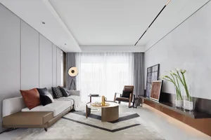 A modern living room featuring fabric seating, glass coffee table, and metal accents.