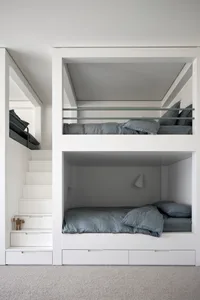 A modern minimalist bedroom with white walls and wooden bunk beds