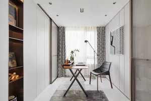 A minimalist home office with a sleek desk, black chair, and sophisticated decor.