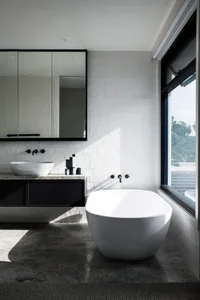 A modern bathroom featuring concrete and porcelain tiles, with a freestanding tub and a floating vanity.