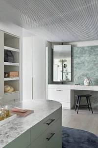 A modern utility room featuring marble countertops and a white wooden cabinet.
