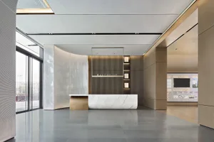 Modern, minimalist commercial lobby featuring marble, wood, and glass materials.