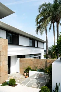 Modern house exterior with concrete walls and a stone pathway.