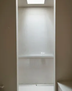 Modern white minimalist interior with a single shelf showcasing two small white bottles.