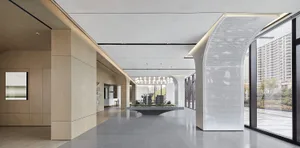 Modern lobby with glass walls and concrete floor.