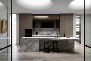 A modern kitchen with a marble countertop, wooden cabinets, and stainless steel appliances.