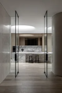 Modern kitchen with marble countertops and wooden flooring.