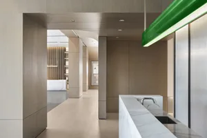 Modern office hallway with marble countertops, concrete walls, and aluminum columns.