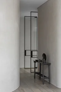 A sleek, modern console table with a minimalist design, featuring a metal base and polished metal surface.