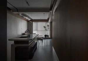Modern kitchen with concrete countertop and minimalist design, featuring sleek lines and clean surfaces.