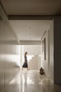 A minimalist hallway featuring a concrete staircase and flooring.