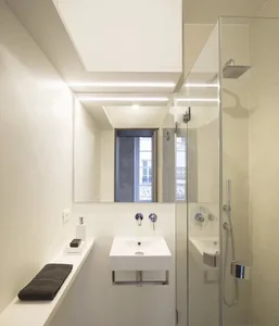 Modern bathroom with glass shower enclosure and porcelain fixtures.
