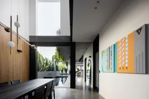 Modern residential interior with concrete walls, black metal elements, and glass ceilings.