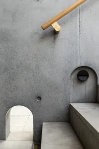 A minimalist radio room with a concrete wall and a circular window.