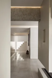 A modern entryway with a concrete tiled floor, large window, and minimalistic design.