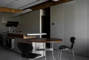 Modern kitchen with minimalist design, featuring a wooden table, black chairs, and a wood-and-metal kitchen island.
