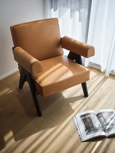 A modern leather armchair with dark wooden legs and a cushioned seat and backrest.