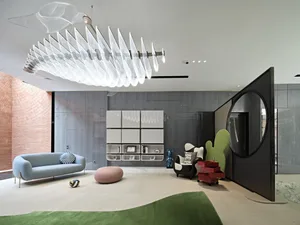 Modern living room with glass walls, metal accents, and fabric furnishings in white and black tones.