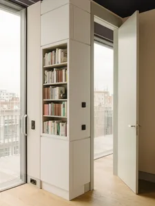 Modern minimalist bookshelf with white wall and door.