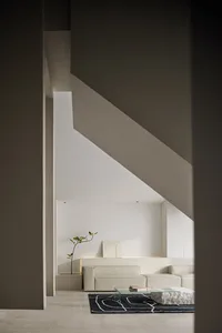 Modern minimalist living room with concrete walls and furniture.
