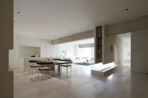 Modern, open-plan living and kitchen area with marble and concrete finishes.