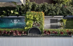 Aerial view of a modern patio featuring greenery, tile, and furniture.