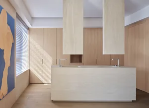 A modern kitchen with marble countertops and cabinets.