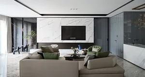 A modern living room featuring a marble wall, comfortable furniture, and a sleek TV setup.