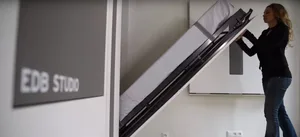 A wall-mounted bed with hidden storage compartments.