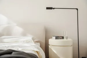 A minimalist bedroom featuring a bed and lamp beside it.
