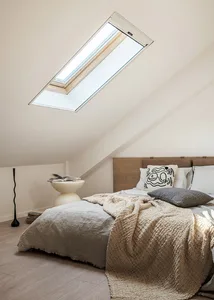 A minimalist bedroom featuring a wooden window with a skylight.