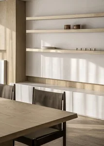 Minimalist kitchen with concrete countertops, wooden cabinets, and metal accents.