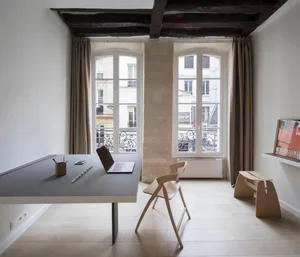 Modern minimalist living room with wooden furnishings and a sleek, gray table.