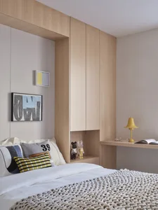 Modern minimalist bedroom featuring wooden walls and a comfortable bed.