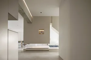 Minimalist living space with concrete walls and floating ceiling beam