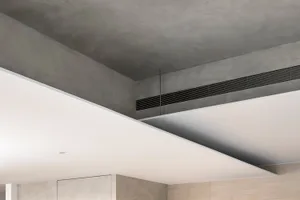 A modern interior space featuring exposed concrete walls and ceiling.