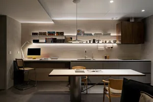 A modern residential kitchen with white countertops, wooden cabinets, and a combination of light and dark tones.